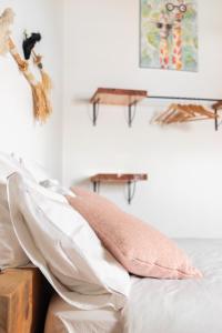 un letto con un cuscino rosa sopra di Casa Bombordo a Carrapateira