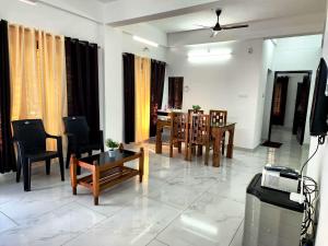 a living room with chairs and a table and a television at GOPURAM in Trivandrum