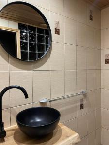 La salle de bains est pourvue d'un lavabo noir et d'un miroir. dans l'établissement Ristiku Guesthouse, à Kuressaare