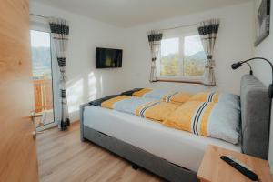 a bedroom with a bed and two windows at Bergblickapartments in Spital am Pyhrn