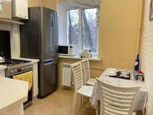 a kitchen with a table and chairs and a microwave at Aq Shanyraq Atakent in Almaty