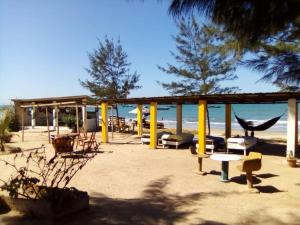 Ghana Town的住宿－One Love Beach Bar，一个带吊床和椅子的海滩和大海