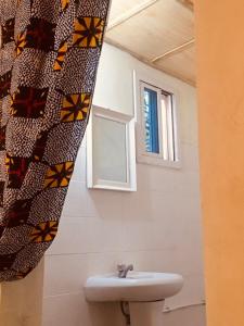 La salle de bains est pourvue d'un lavabo et d'une fenêtre. dans l'établissement One Love Beach Bar, à Ghana Town