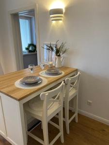 a dining room table with two chairs and a table with glasses at Ferienwohnung am See im Fichtelgebirge in Nagel