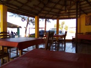 un restaurant avec des tables et des chaises et un parking dans l'établissement One Love Beach Bar, à Ghana Town