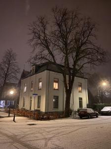 um edifício com uma árvore em frente à noite em De Oude Pastorie em Bunschoten
