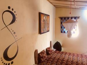 Ghana Town的住宿－One Love Beach Bar，卧室配有一张床,墙上挂着一幅画