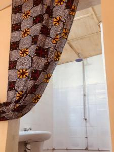 a bathroom with a shower and a tie with butterflies on it at One Love Beach Bar in Ghana Town