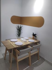 mesa de comedor con 4 sillas y lámpara en Midnight Homestay Youth City en Nilai