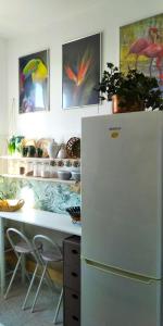 a kitchen with a white refrigerator and a table withicans at Casa Amari alla Zisa HOSTEL in Palermo