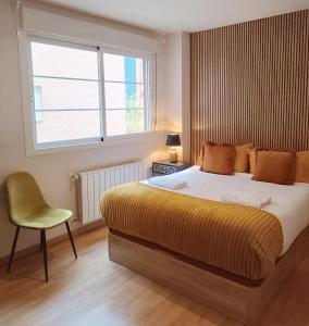 a bedroom with a bed and a chair and a window at Fridda House Atocha Madrid in Madrid