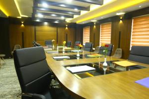 a conference room with a large wooden table and chairs at Hotel White Rock in Bangalore