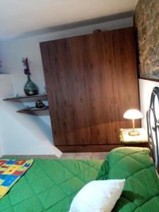 a bedroom with a green bed and a wooden cabinet at La tana delle coccinelle in Capracotta