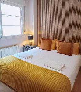 a bedroom with a large bed with a yellow blanket at Fridda House Atocha Madrid in Madrid