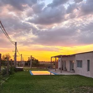 ein Haus mit Sonnenuntergang im Hintergrund in der Unterkunft Quinta Loma Hermosa in Diamante