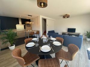uma sala de jantar com uma mesa preta e cadeiras em LE BEC - Maison 6 personnes - La Trinite-sur-Mer em La Trinité-sur-Mer