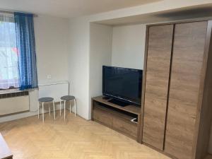 ein Wohnzimmer mit einem TV und 2 Hockern in der Unterkunft Apartmán Rekys in Jiřetín pod Bukovou
