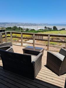 una terraza con 2 sillas de mimbre y una mesa en Azul petroleo, en Concón