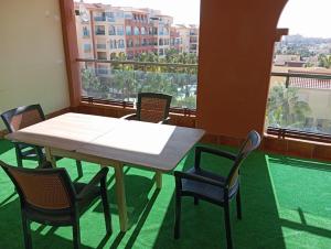 a table and chairs in a room with a balcony at Center Paradise Almerimar in Almerimar