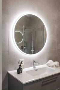 ein Bad mit einem Waschbecken und einem Spiegel in der Unterkunft Nyleilighet midt i sentrum in Leknes