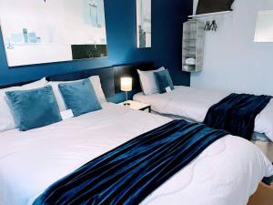 2 Betten in einem Zimmer mit blauen Wänden in der Unterkunft Aspen House in Birmingham