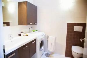 un bagno con lavatrice e lavandino di TOP BELLAVISTA MOLVENO a Molveno Altre 36 foto