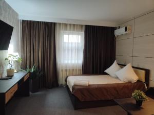 a hotel room with a bed and a window at Отель Бестау in Aksay