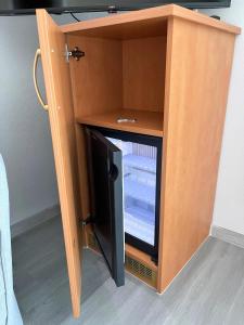 a small wooden cabinet with a refrigerator in it at Hotel Passat in Borkum