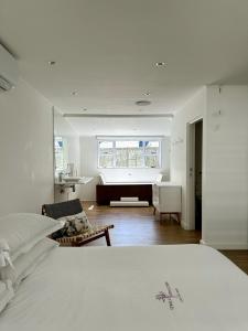 a white bedroom with a bed and a bathroom at Riebeeck Villa - 5 min walk to Franschhoek Central in Franschhoek