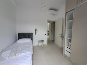 a white bedroom with a bed and a table at paris villas in Mitika