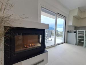 a fireplace in a living room with a balcony at paris villas in Mitika