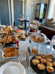 een buffet met verschillende soorten brood en zoete deegwaren bij CasAunoE Boutique Hotel in Olbia