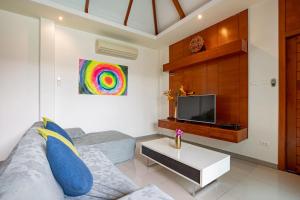 a living room with a couch and a tv at Cozy 2Br Pool Villa Lexi*200m to Rawai Beach*Kids Park in Rawai Beach