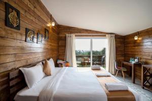 Cama grande en habitación con paredes de madera en Stone Wood Resort, Mandrem en Mandrem