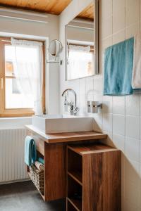 ein Bad mit einem Waschbecken und einem Spiegel in der Unterkunft Gästehaus Fritz in Mittelberg