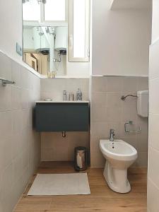 ein Badezimmer mit einem Waschbecken, einem WC und einem Spiegel in der Unterkunft Casa Cavour in Palermo