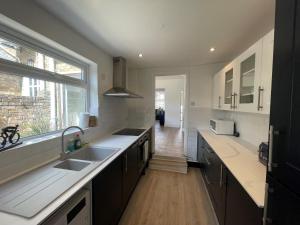 a large kitchen with a sink and a window at Windsor Stunning Three Bedroom House in Windsor