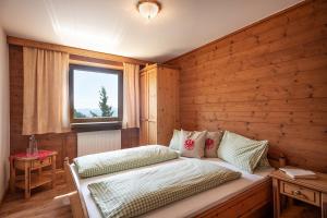 1 dormitorio con 1 cama en una pared de madera en Berggasthof Rofan, en Maurach