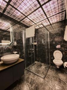 uma casa de banho com um chuveiro, um WC e um lavatório. em Elif Otel em Ereğli