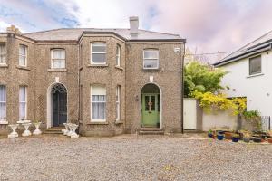 uma grande casa de tijolos com uma porta verde em Oakwood House em Dublin