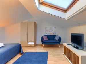 Schlafzimmer mit einem blauen Bett und einem TV in der Unterkunft Holiday Home Nadija - PUL428 by Interhome in Vodnjan
