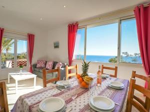 una sala da pranzo con tavolo e vista sull'oceano di Holiday Home La Rocade - TEU110 by Interhome a Espéro-Pax