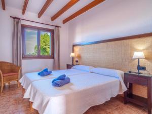 a bedroom with two beds with blue towels on them at Apartment Finca Can Corritx - MUO125 by Interhome in Muro