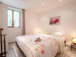 a white bedroom with a bed with flowers on it at Holiday Home Magali - HYE550 by Interhome in Hyères