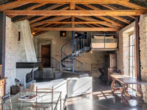 ein Wohnzimmer mit weißen Stühlen und einer Treppe in der Unterkunft Holiday Home Antico Borgo del Riondino by Interhome in Trezzo Tinella
