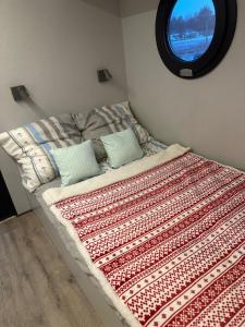 ein Bett mit einer Decke und einem Fenster in der Unterkunft Houseboat Water Boy apartament pływający dom na wodzie łódź in Breslau