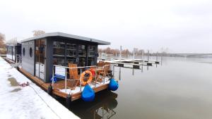 ein kleines Boot auf dem Wasser neben einem Dock in der Unterkunft Houseboat Water Boy apartament pływający dom na wodzie łódź in Breslau