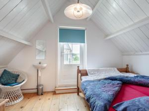 a bedroom with a bed and a window at Holiday Home Dijkhuisje by Interhome in Brouwershaven