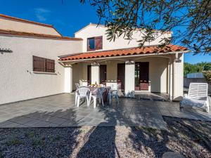 a patio with a table and chairs in front of a house at Holiday Home Lotissement du Stade by Interhome in Saint-Cyprien