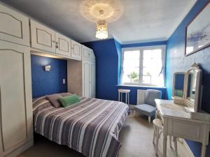 een blauwe slaapkamer met een bed en een wastafel bij Holiday Home La Congrière by Interhome in Cancale